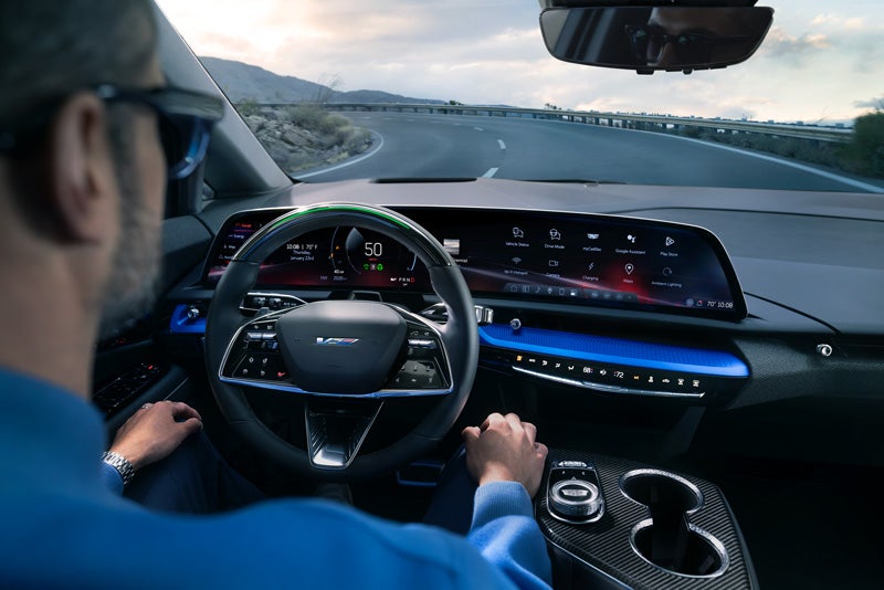 Front View of the 2026 OPTIQ-V Driving Through the Dusk Utilizing its Headlights | Moses Cadillac of Huntington in Huntington WV